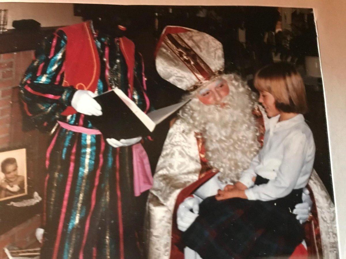 Oude familiefoto van Piet en Sinterklaas bij een kind aan de haard